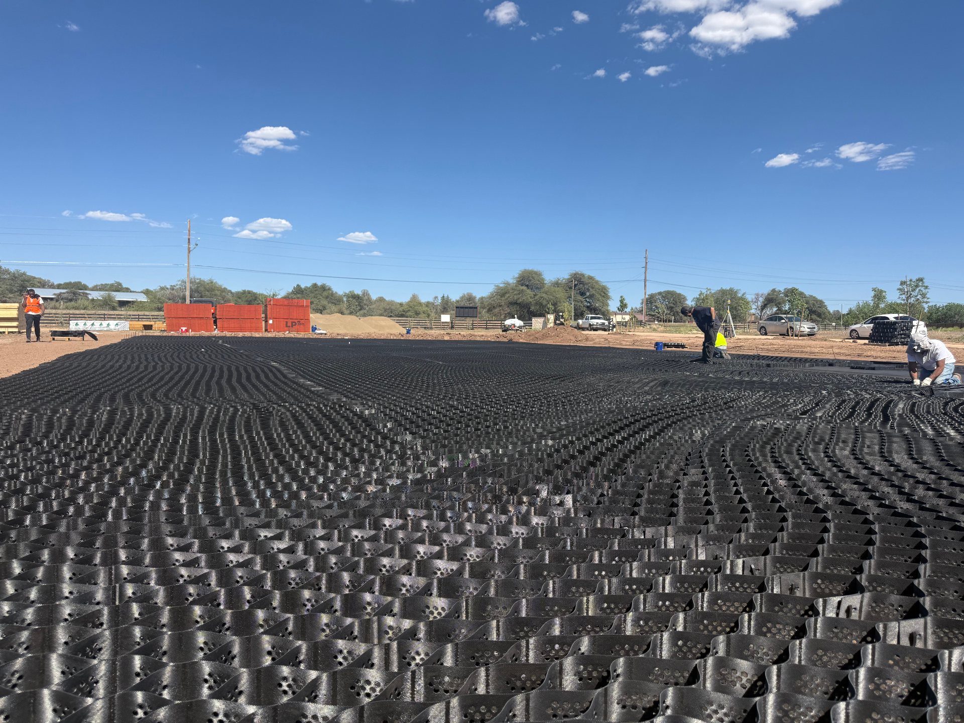 Prescott AZ Outdoor Arena Geocell Install Geocell grid base installation for an outdoor riding arena in Prescott, Arizona under clear blue sky